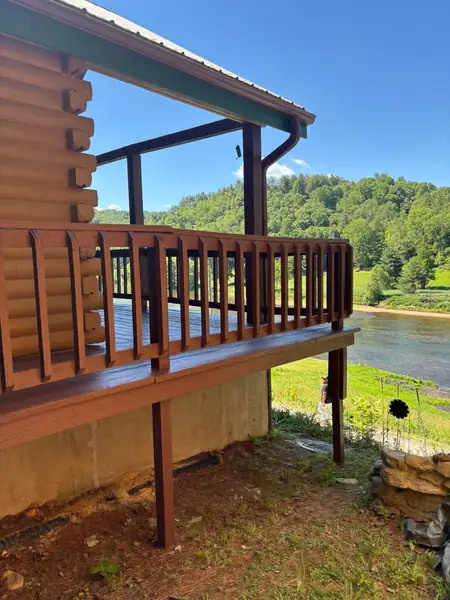 Stained deck, railing and posts on a log home overlooking a river