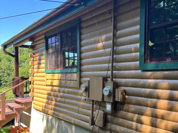 Log siding and green window trim painted by ADA Design and Build