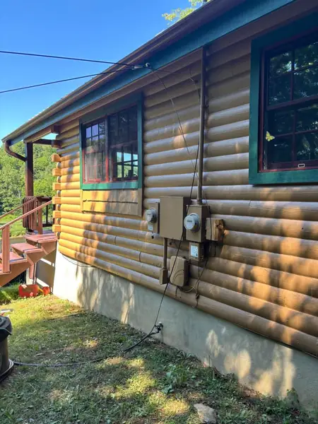 Painted log siding with green window trim